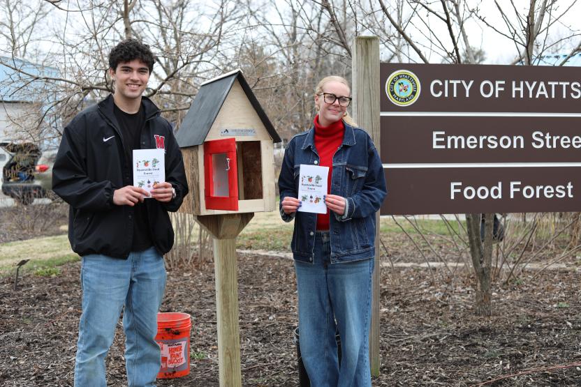 Students with resource guide in the food forest